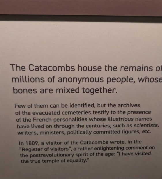 An interpretation panel in the Paris Catacombs explaining that the ossuary holds the remains of millions of anonymous people